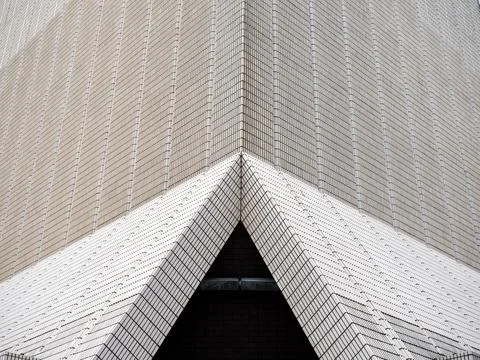 Abstract geometric architecture featuring triangular entrance framed by rep.. Stock Photos