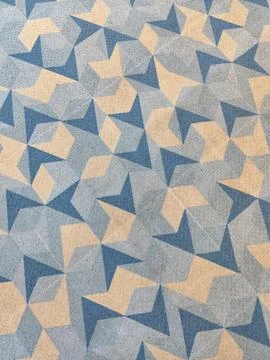 An abstract geometric pattern of blue star and beige triangle shapes with a b Foto stock