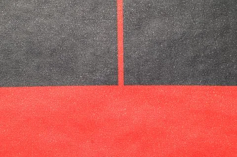 Abstract geometric pattern with contrasting red and gray textured surfaces Stockfoto's