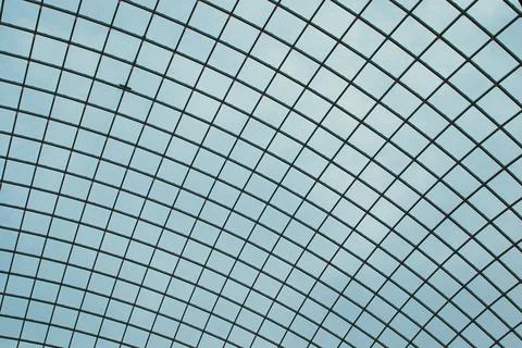 Abstract geometric pattern of a glass ceiling against a clear blue sky. Stock Photos