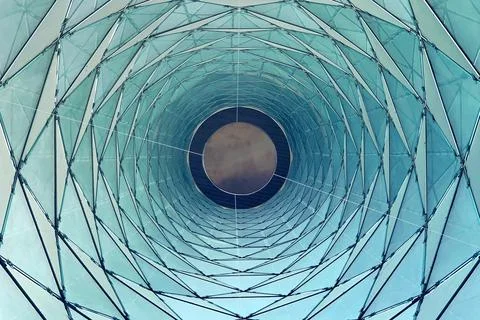 Abstract geometric pattern of a modern building's glass facade looking up Stock Photos