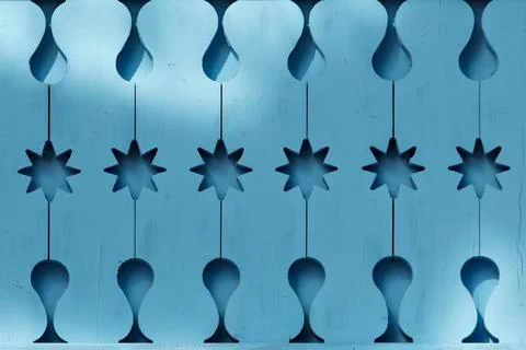 Abstract geometric pattern with star and drop shapes carved into a blue woode Stock Photos