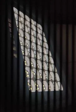 Abstract geometric sunlight reflection on wall through vertical window blind Stock Photos