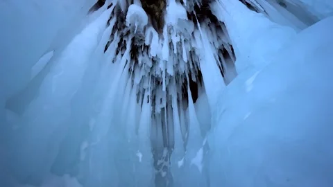 Abstract giant epic ice surges at mountain foothills, enormous icicles on cave  Stock Footage 317963432