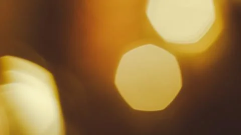 Abstract golden bokeh lights with hexagonal shapes and soft focus background Stock Photos