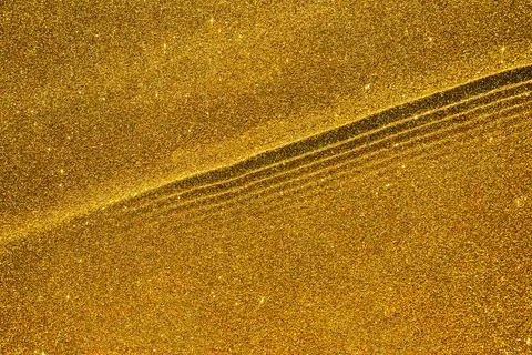 Abstract golden glitter texture with waves and ripples, sparkling background Stock Photos