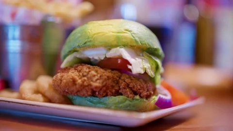 Abstract Green And Yellow Burger Bun With Chicken On Plate In Bar Stock Footage 237694222