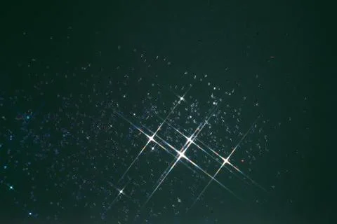 Abstract green background with sparkles in the shape of stars. Stock Photos