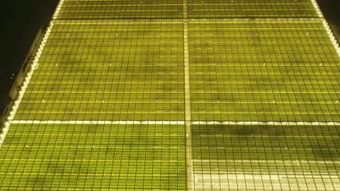 Abstract green geometric background. Illuminated greenhouses at night. Aerial Stock Footage 152171679