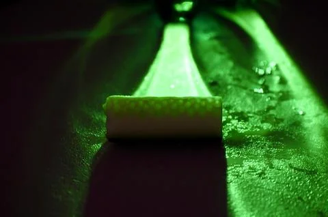 Abstract green glowing light beam and a close-up of a textured, wet cucumber Stock Photos