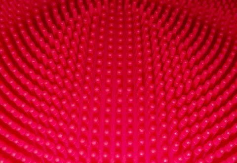 Abstract, halftone radial pattern in 3D relief, composed of red dots on a blurre Stock Photos