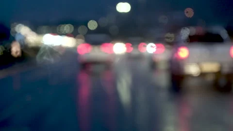 Abstract handheld defocused view through windshield driving on wet rainy road Stock Footage 312928493