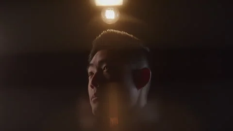 Abstract Headshot of Light Bulb Being Turned on Above Diverse Young Man in Dark Stock Footage 270304827