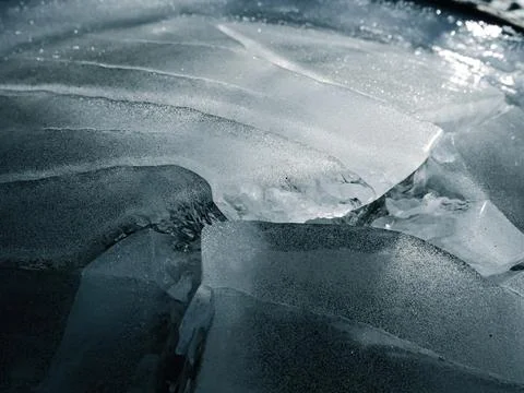 Abstract ice texture. Blue background with cracks on surface. Close-up. Stock Photos