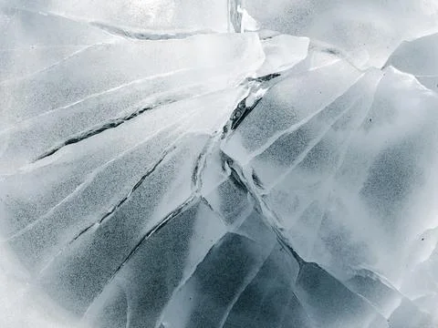 Abstract ice texture. Blue background with cracks on surface. Close-up. Stock Photos