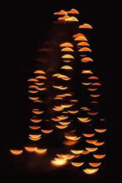 Abstract image featuring bright orange crescent bokeh shapes against a dark.. Stock Photos