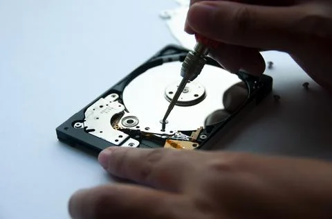 The abstract image of inside of hard disk drive with technician fixing using Stock Photos
