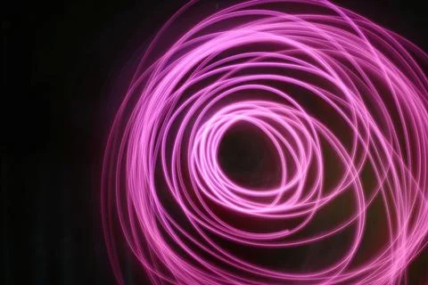 Abstract image of pink neon light painting in a circular and spiral pattern.. Stock Illustration