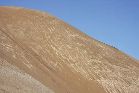 Abstract image of sand dune and clear blue sky Stock Photos