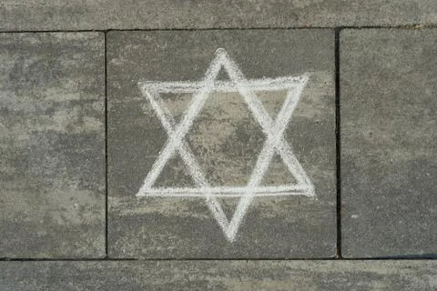 Abstract image of six pointed star, written on grey sidewalk Stock Photos