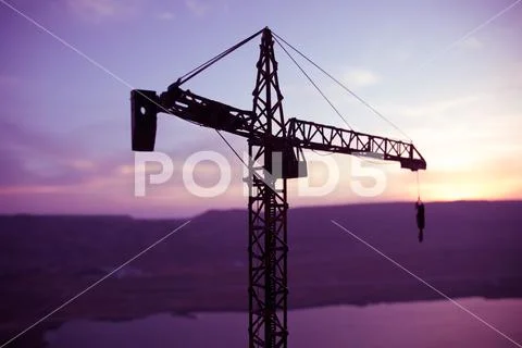 Abstract Industrial background with construction crane silhouette over amazin Stock Photos