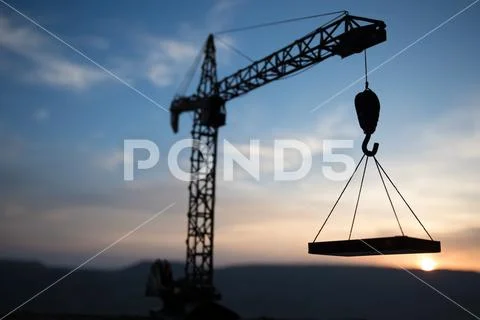 Abstract Industrial background with construction crane silhouette over amazin Stock Photos