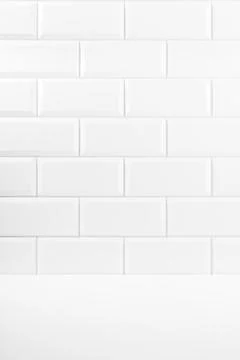 Abstract interior with white ceramic rectangle tiles on wall and wood floor o Stock Photos