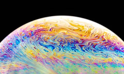 Abstract iridescent patterns on a soap bubble surface against black backgroun Illustrazione stock