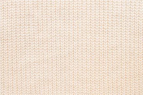 Abstract knitted background. Wool beige sweater texture. Close up picture of Stock Photos