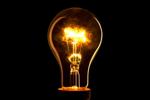 Abstract light bulb on the black background. Lamp light in the dark. Electric Foto stock