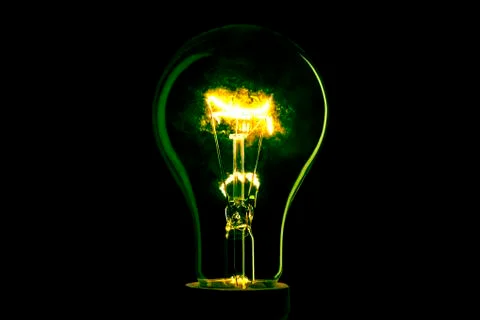 Abstract light bulb on the black background. Lamp light in the dark. Electric Stock Photos