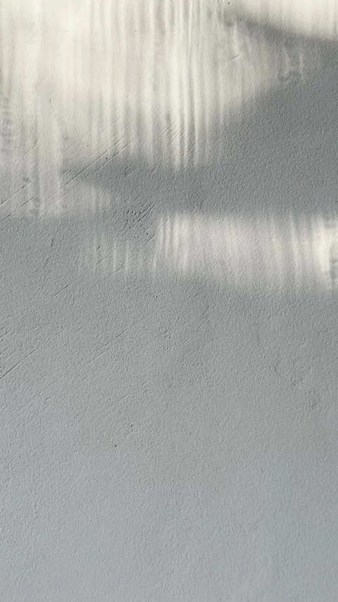 Abstract light patterns dancing across textured grey concrete wall for minimalis 스톡 동영상 333691232