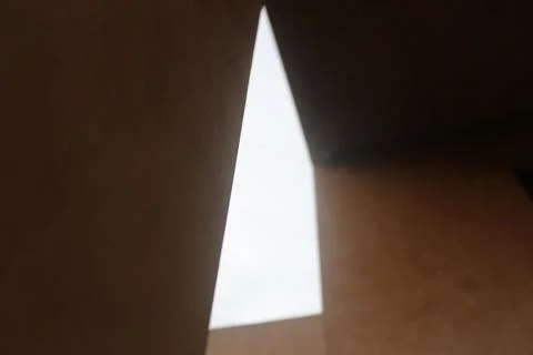 Abstract Light Triangular Gap in Brown Walls Stockfoto's