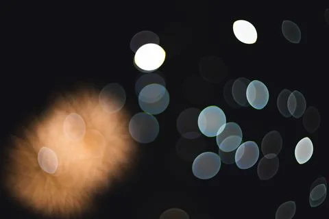 Abstract long exposure light streaks and glowing bokeh circles against a da.. Stock Photos