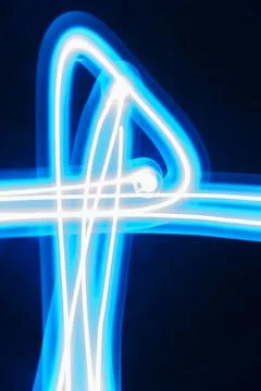 Abstract long exposure of tangled blue glowing light trails Stock Photos