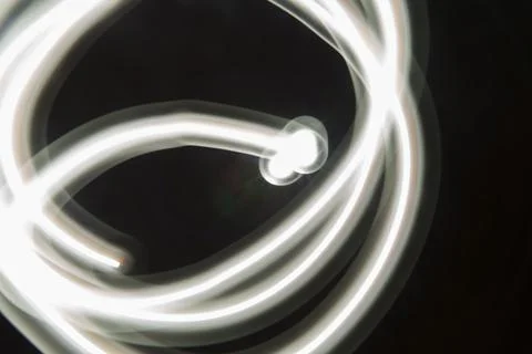 Abstract long exposure of tangled white glowing light trails over Stock Photos