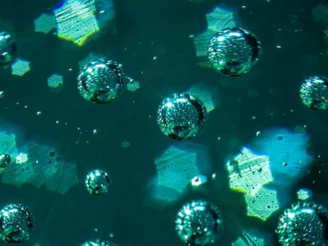 Abstract macro of air bubbles embedded in glass with star shaped bokeh. Stock Photos