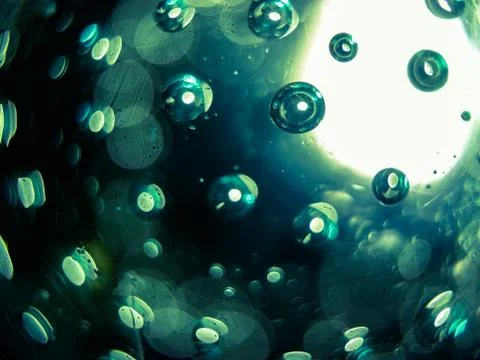 Abstract macro of air bubbles embedded in glass with green accents. Stock Photos