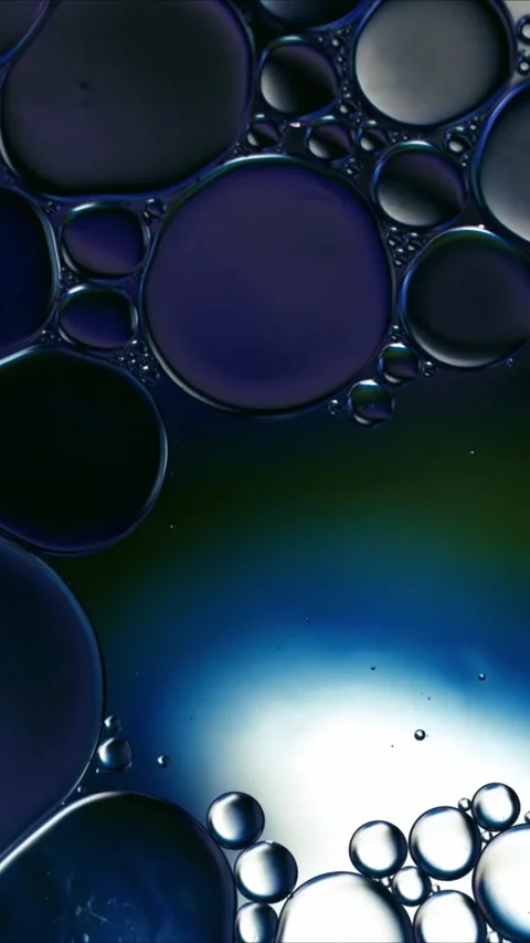 Abstract macro background of blue and teal oil bubbles floating in water for Video stock 347692061