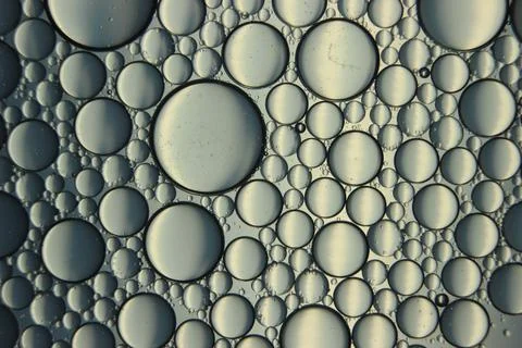 Abstract macro background of oil circles floating over water surface . Stock Photos