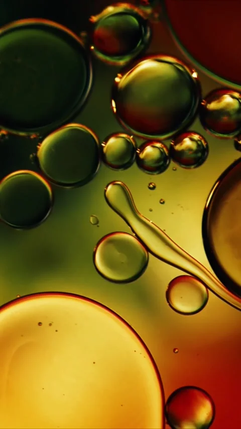 Abstract macro liquid motion with floating oil bubbles in golden green and Stock-Footage 347692607