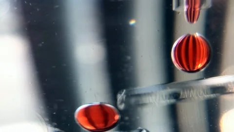 Abstract Macro Red Bubbles dropping in sync Stock Footage 100606977