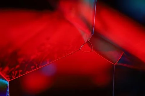 Abstract macro of red liquid reaction in dark cubic glass container 写真素材