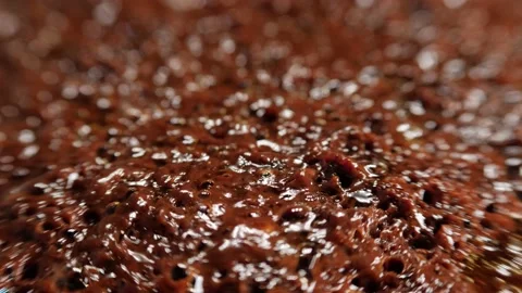 Abstract macro shot of bubbles in boiling thick dark brown liquid, backlit. Stock Footage 212077304