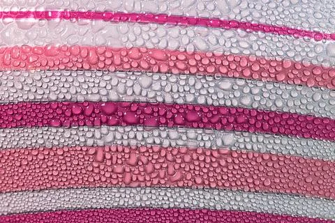 Abstract macro texture of water drops on pink and white striped background Stock Photos