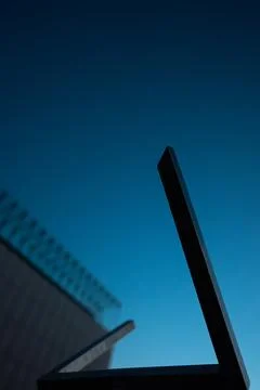 Abstract metal geometric shape on blue evening sky background Stock Photos