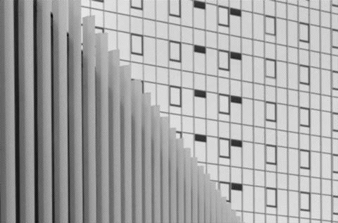 Abstract modern building facade with repeating windows and vertical lines. Stock Photos