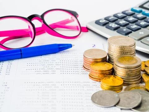 Abstract money saving. Stack of coins, calculator, pink glasses  and blue pen Stock Photos