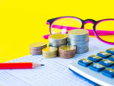 Abstract money saving. Stack of coins, calculator, pink glasses  and red penc Stock Photos