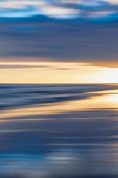 Abstract motion blur capturing the ocean and sky at sunset. Stock Photos